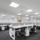 An empty gray call center office with tables and chairs, well-lit