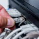 Technician connecting network cables to switches. Connecting cables in server cabinet